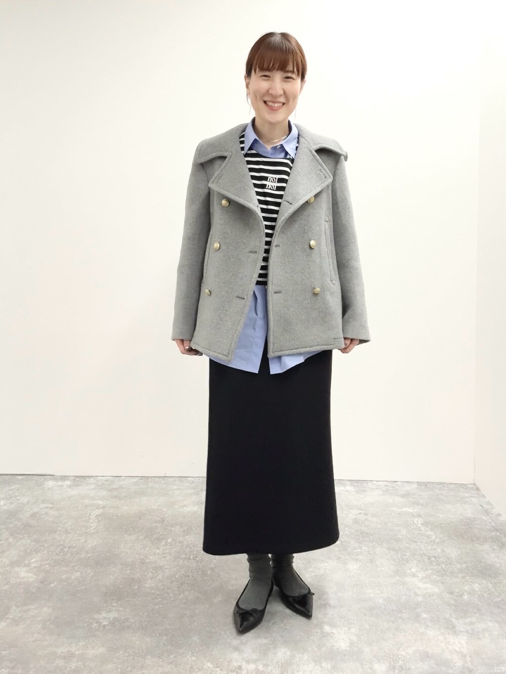 ブラック系のスカート、ブラック系のTシャツ/カットソー、グレー系のピーコートを着用したレディースの秋コーディネートの4枚目の写真