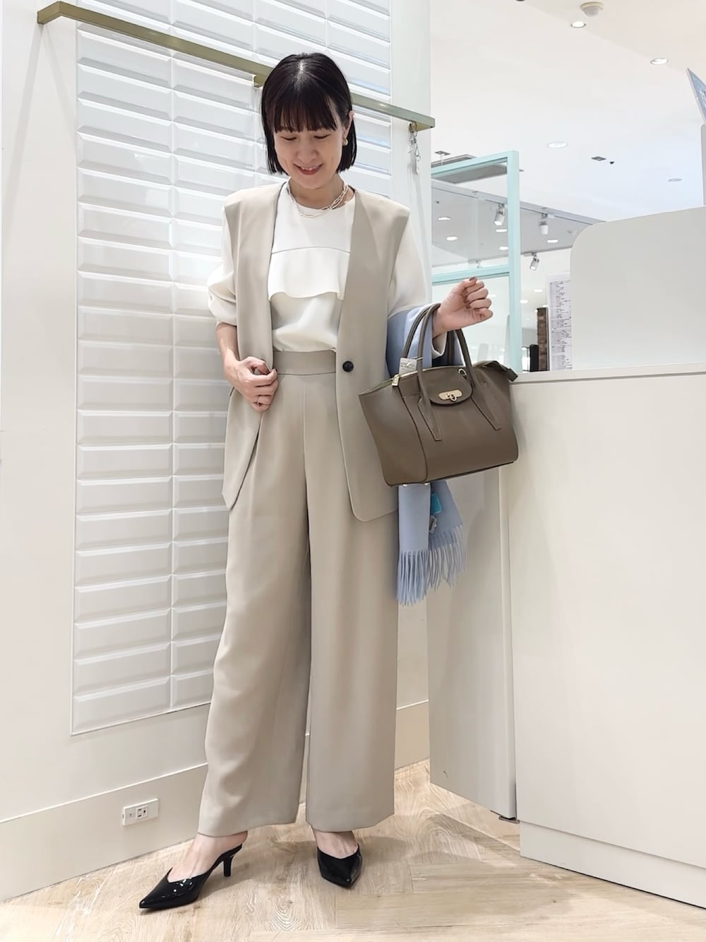 ブラウン系のショルダーバッグ、ベージュ系のその他パンツ、ベージュ系のベストを着用したレディースの秋コーディネートの2枚目の写真