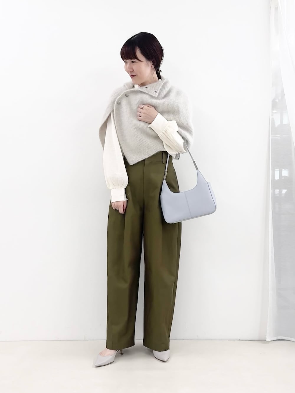 ブルー系のショルダーバッグ、グリーン系のチノパンツ、ホワイト系のシャツ/ブラウスを着用したレディースの秋コーディネートの2枚目の写真