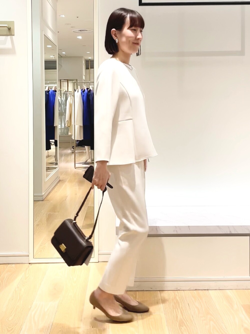 ホワイト系のその他パンツ、ホワイト系のTシャツ/カットソー、ブラック系のショルダーバッグを着用したレディースの冬コーディネートの5枚目の写真