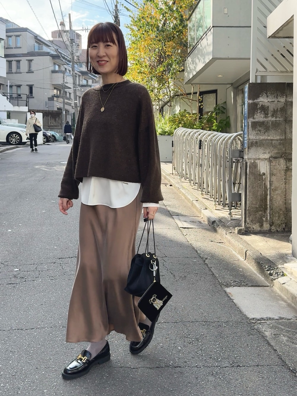 ホワイト系のシャツ/ブラウス、ブラウン系のニット/セーター、ブラック系のその他シューズを着用したレディースの冬コーディネートの3枚目の写真