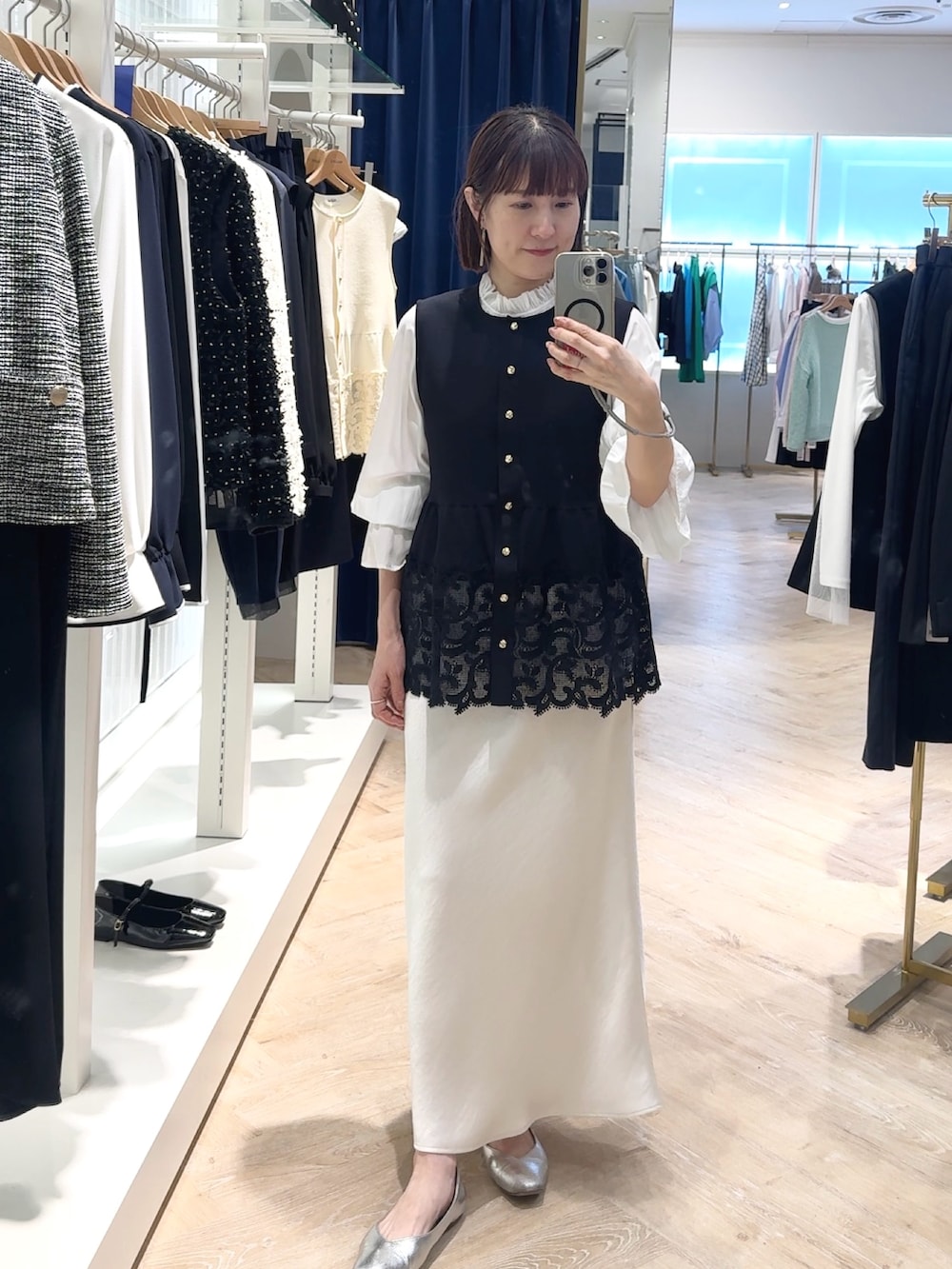 ホワイト系のスカート、ブルー系のベスト、ホワイト系のシャツ/ブラウスを着用したレディースの春コーディネートの4枚目の写真