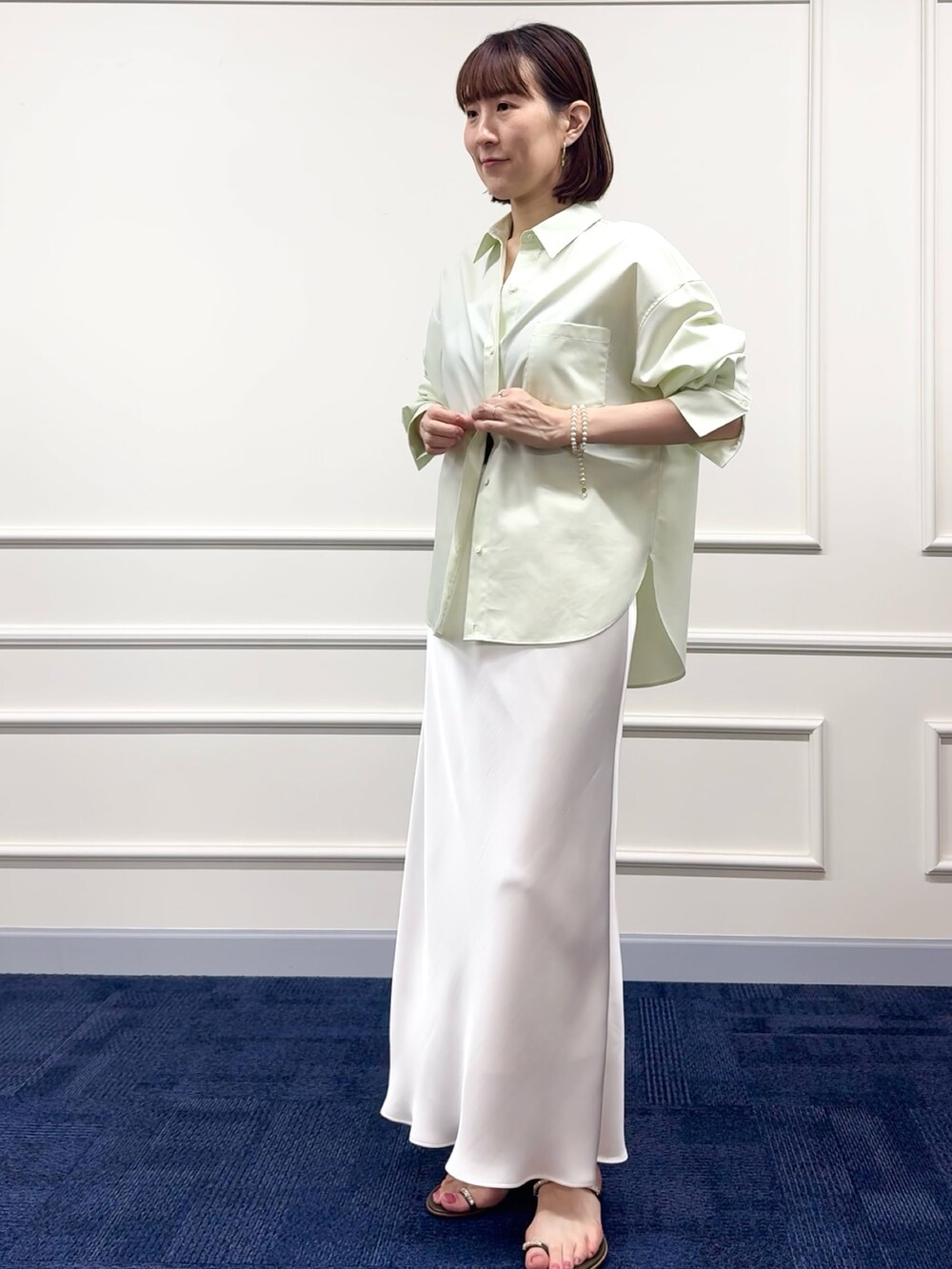 ブラウン系のボストンバッグ、ホワイト系のスカート、グリーン系のシャツ/ブラウスを着用したレディースの冬コーディネートの7枚目の写真