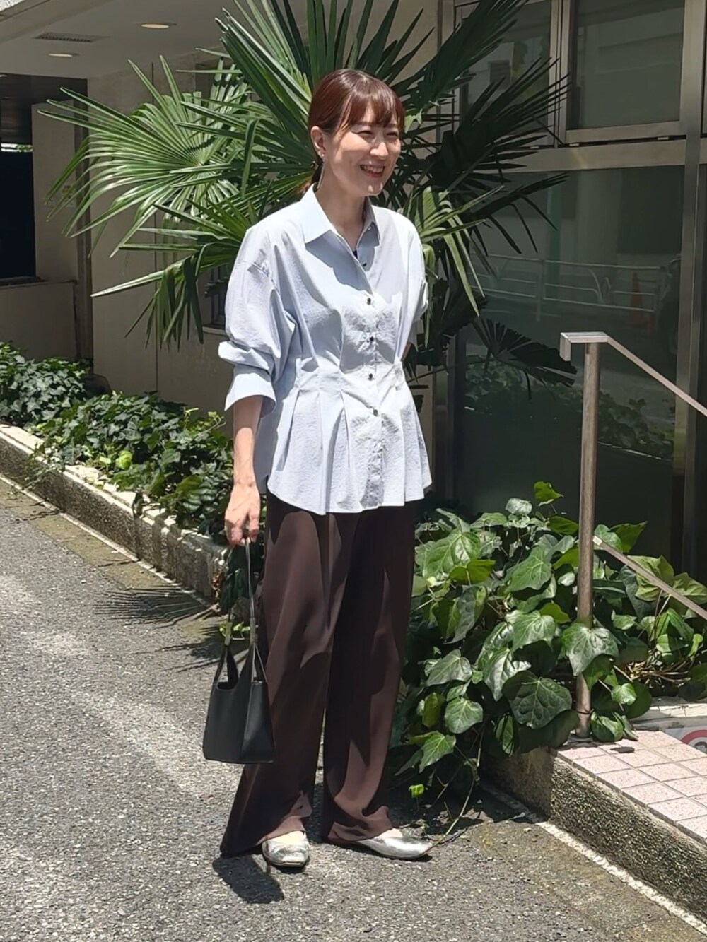 ブラウン系のその他パンツ、ブルー系のシャツ/ブラウス、ブラック系のショルダーバッグを着用したレディースの夏コーディネートの2枚目の写真