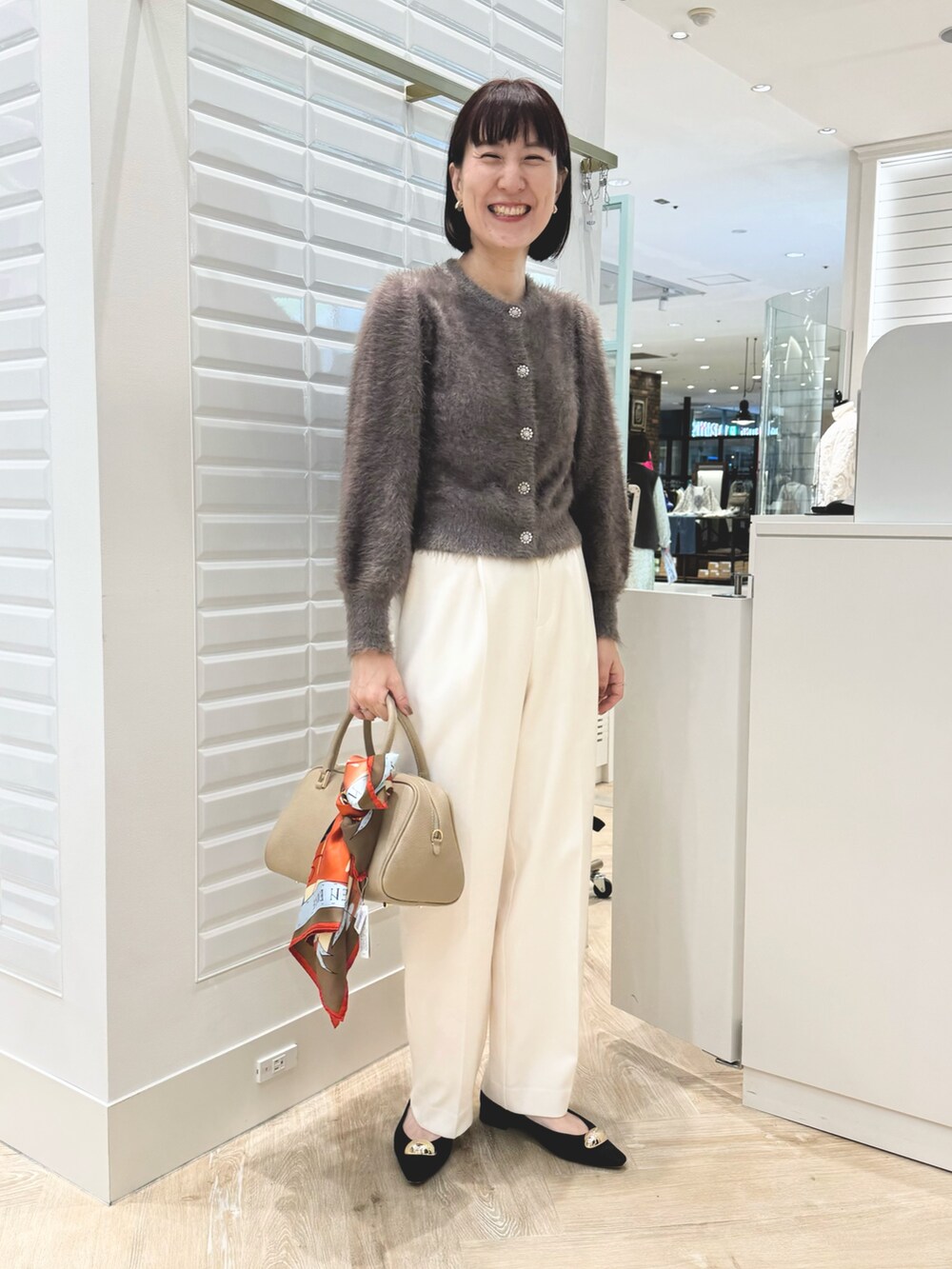ベージュ系のショルダーバッグ、ブラウン系のカーディガン/ボレロ、ホワイト系のその他パンツを着用したレディースの秋コーディネートの4枚目の写真