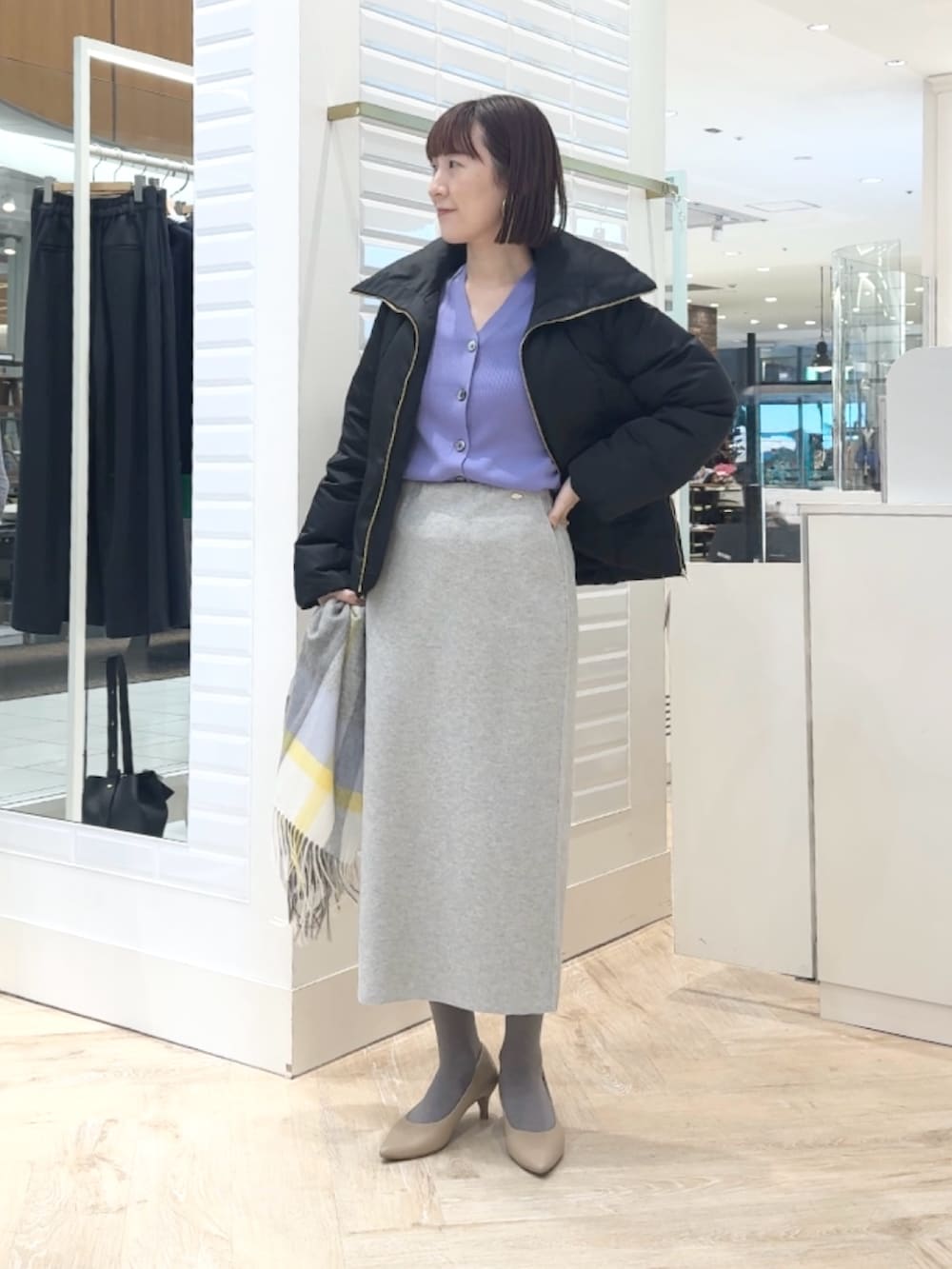 ブラック系のダウンジャケット/コート、パープル系のカーディガン/ボレロ、グレー系のスカートを着用したレディースの秋コーディネートの2枚目の写真