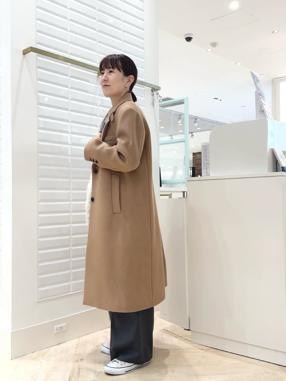 グレー系のベスト、ブルー系のシャツ/ブラウス、ホワイト系のショルダーバッグを着用したレディースの秋コーディネートの9枚目の写真