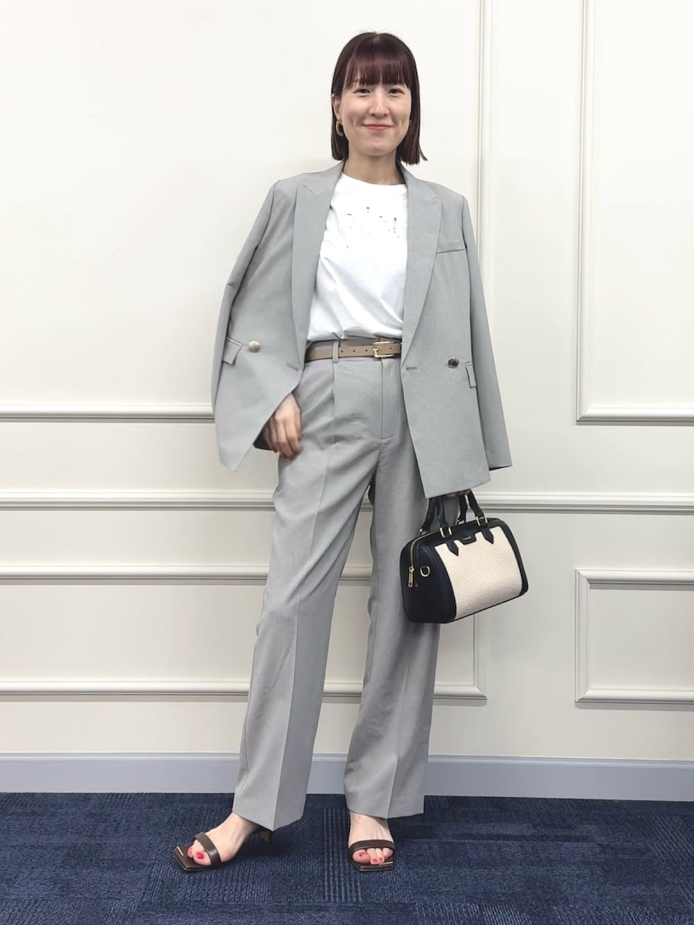 ブラック系のボストンバッグ、グレー系のその他パンツ、ホワイト系のTシャツ/カットソーを着用したレディースの春コーディネートの7枚目の写真