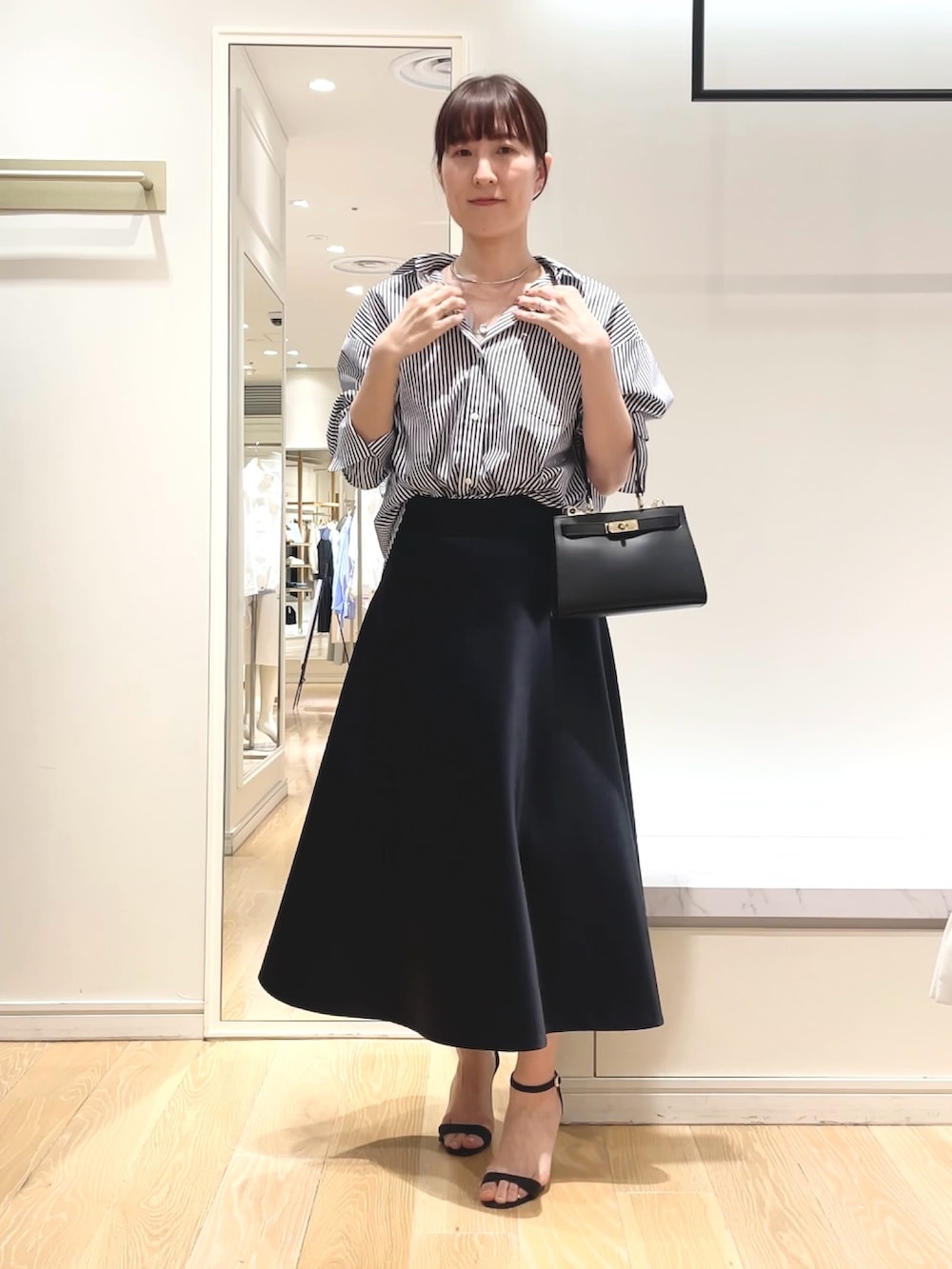 ホワイト系のシャツ/ブラウス、ブルー系のスカート、ブラック系のショルダーバッグを着用したレディースの春コーディネートの7枚目の写真