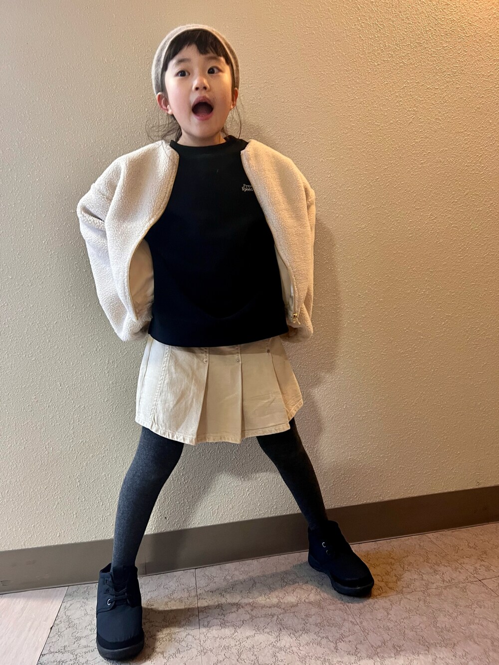 ホワイト系のブルゾン、ブラック系のスウェット、ベージュ系のスカートを着用したキッズの冬コーディネートの4枚目の写真