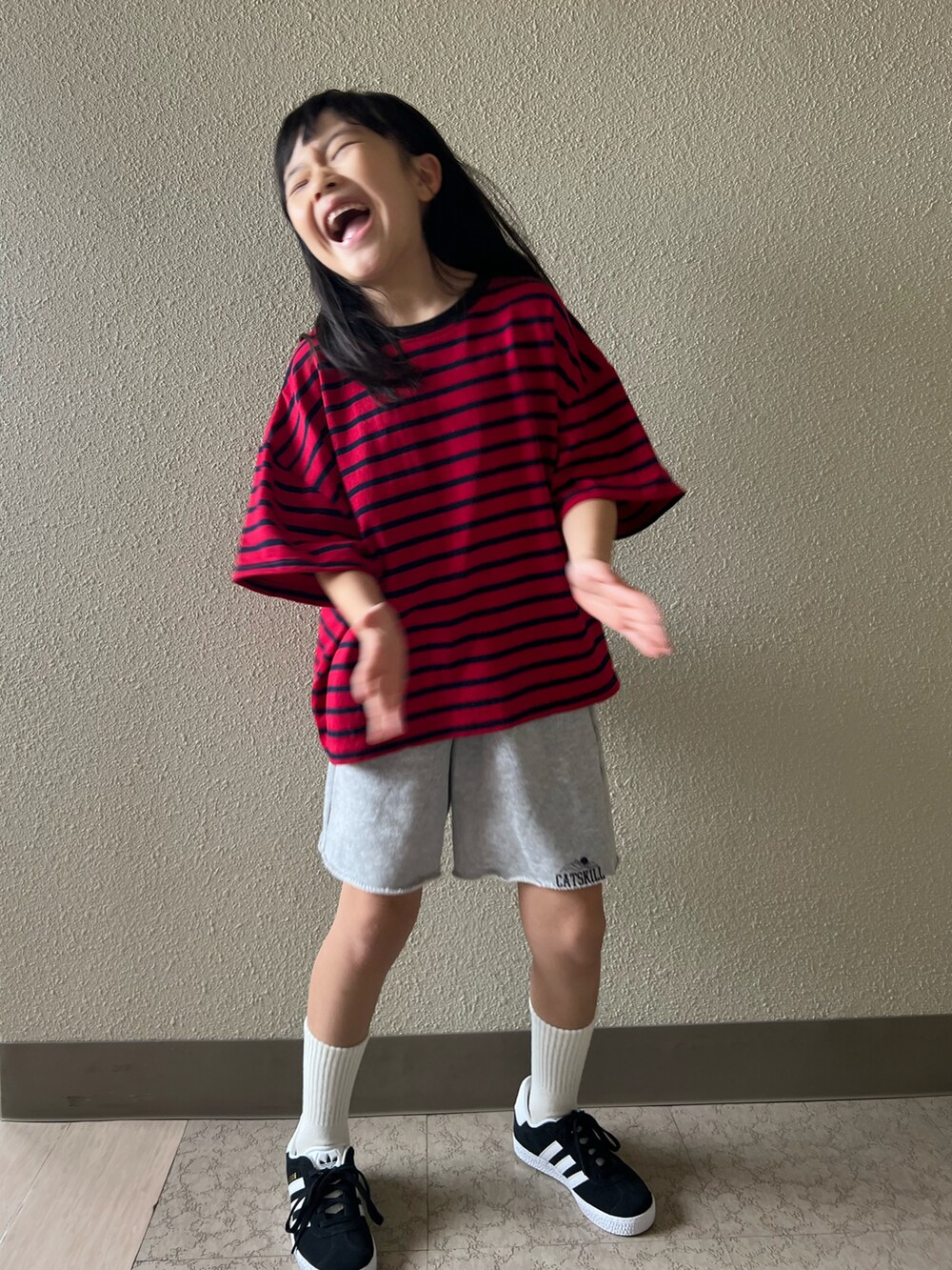 レッド系のTシャツ/カットソー、グレー系のスウェットパンツ、ブラック系のスニーカーを着用したキッズの春コーディネートの3枚目の写真