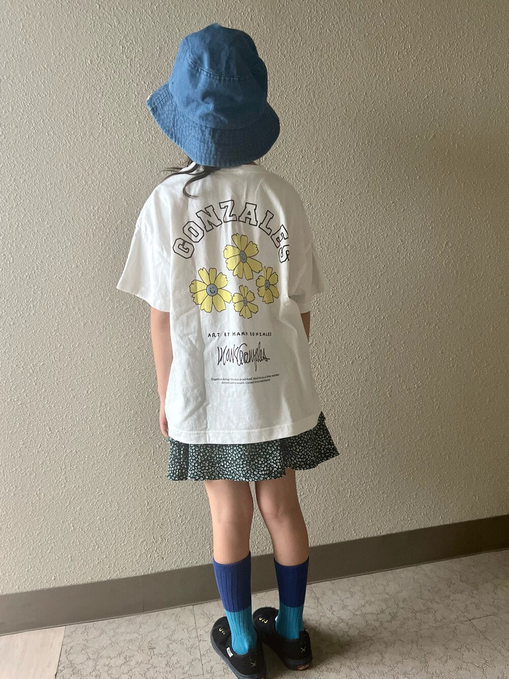 ホワイト系のTシャツ/カットソー、グリーン系のスカート、ブラック系のスニーカーを着用したキッズの春コーディネートの2枚目の写真