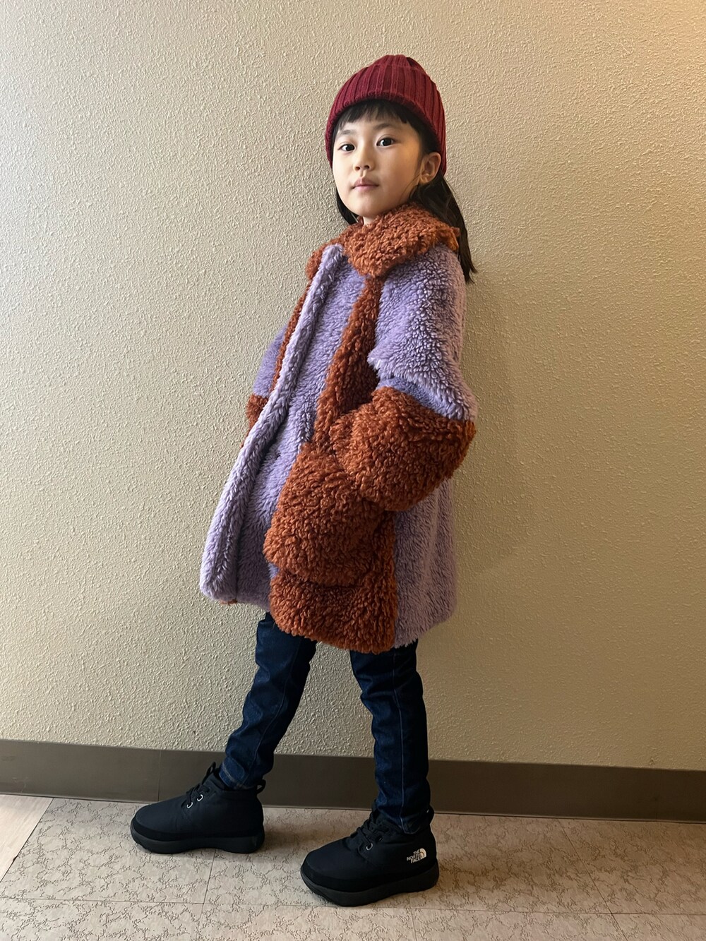 パープル系のジャケット/アウター、ブルー系のデニムパンツ、ブラック系のブーツを着用したキッズの冬コーディネートの3枚目の写真