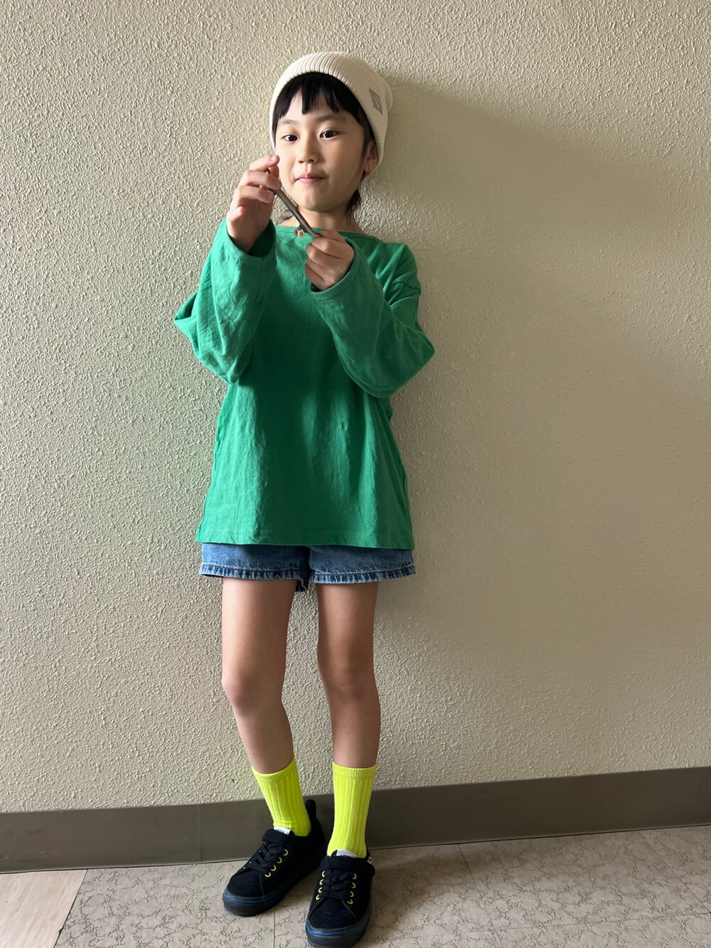 ブルー系のデニムパンツ、グリーン系のTシャツ/カットソー、ブラック系のスニーカーを着用したキッズの春コーディネートの3枚目の写真