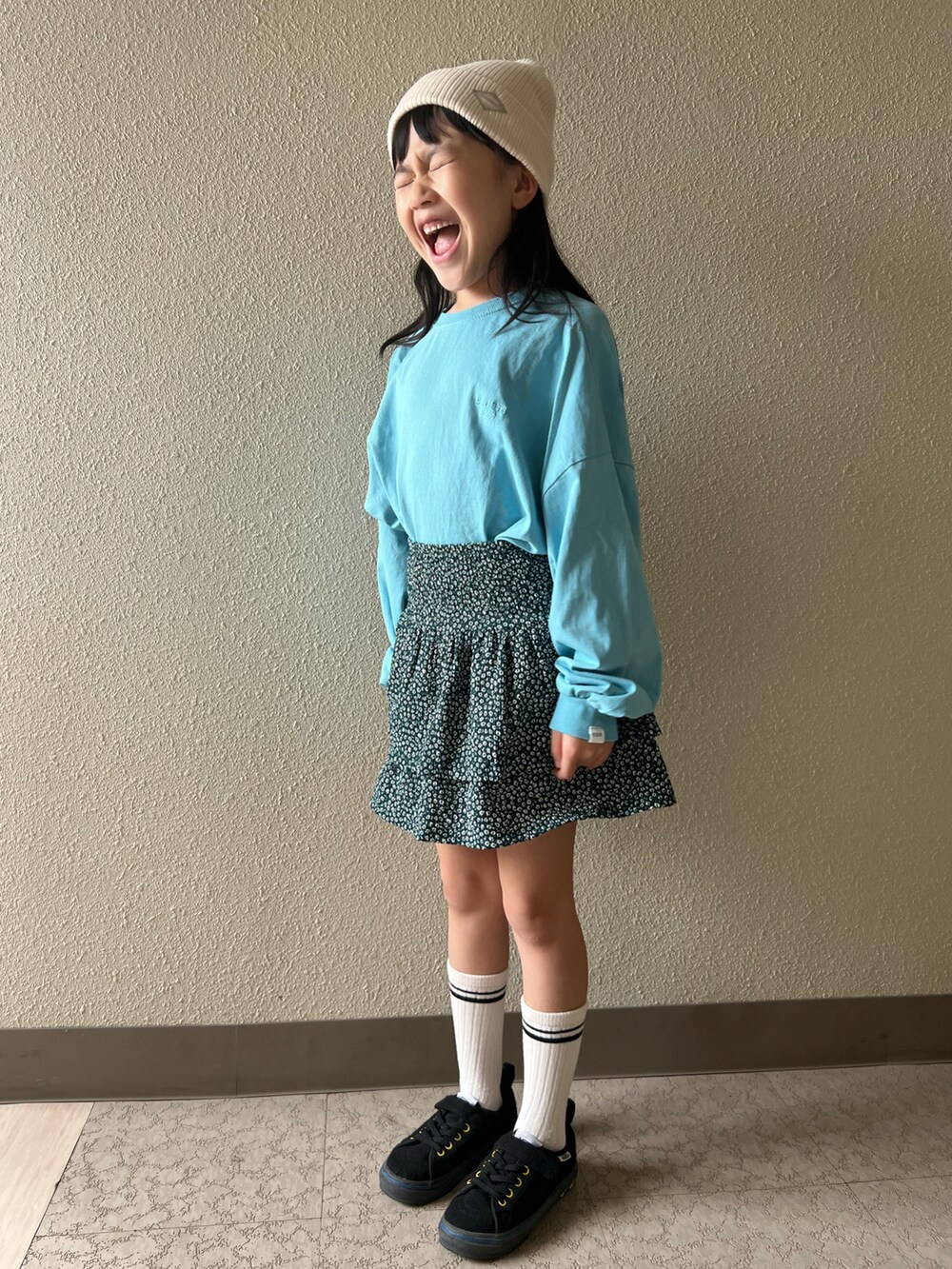 ブルー系のTシャツ/カットソー、グリーン系のスカート、ブラック系のスニーカーを着用したキッズの春コーディネートの3枚目の写真