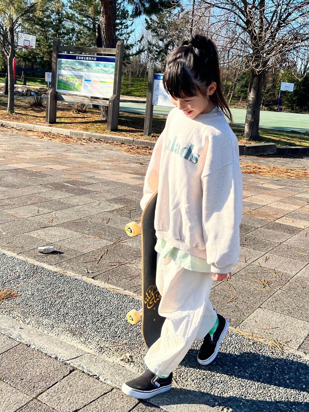 ベージュ系のスウェット、ホワイト系のカーゴパンツ、ブラック系のスニーカーを着用したキッズの冬コーディネートの3枚目の写真