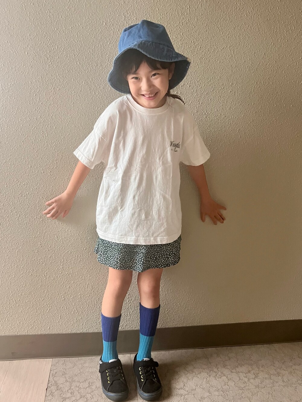 ホワイト系のTシャツ/カットソー、グリーン系のスカート、ブラック系のスニーカーを着用したキッズの春コーディネートの3枚目の写真