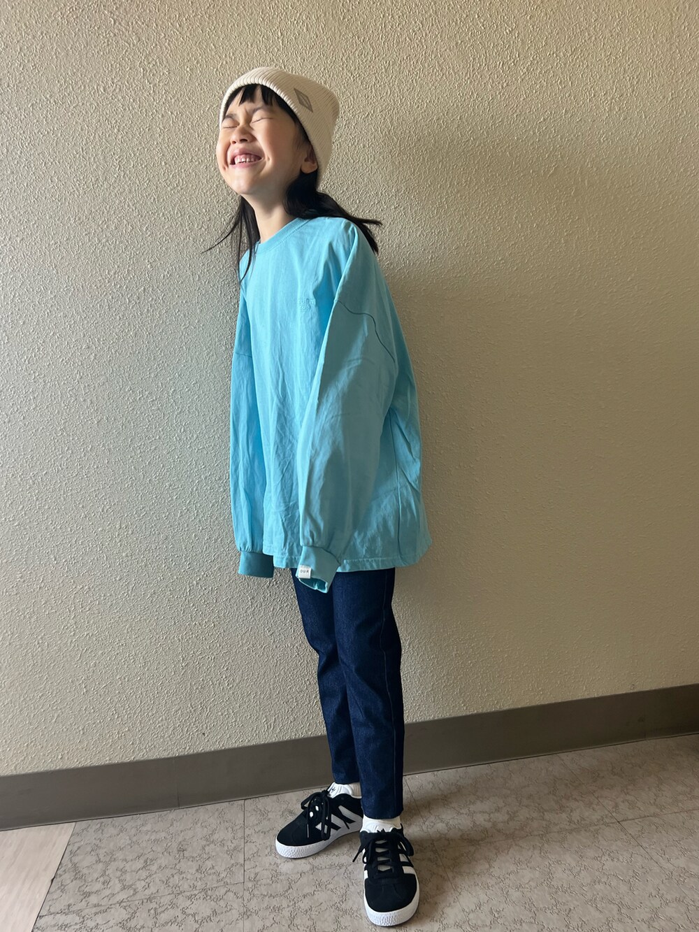 ブラック系のスニーカー、ブルー系のTシャツ/カットソー、ブルー系のデニムパンツを着用したキッズの春コーディネートの3枚目の写真