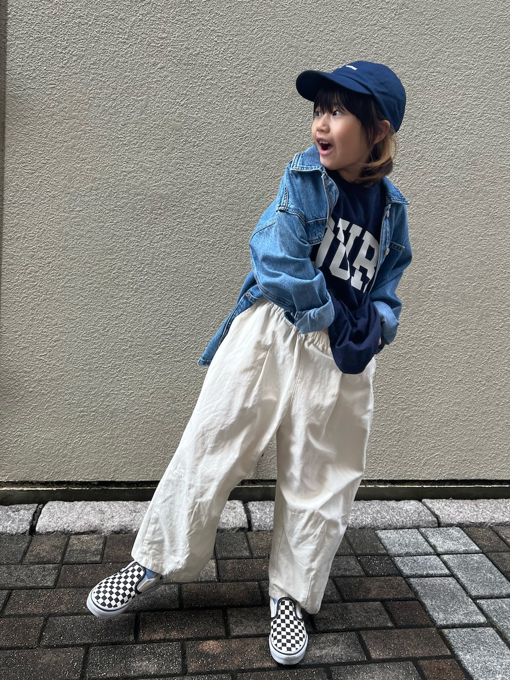 ホワイト系のカーゴパンツ、ブラック系のスニーカー、ブルー系のデニムジャケットを着用したキッズの春コーディネートの3枚目の写真