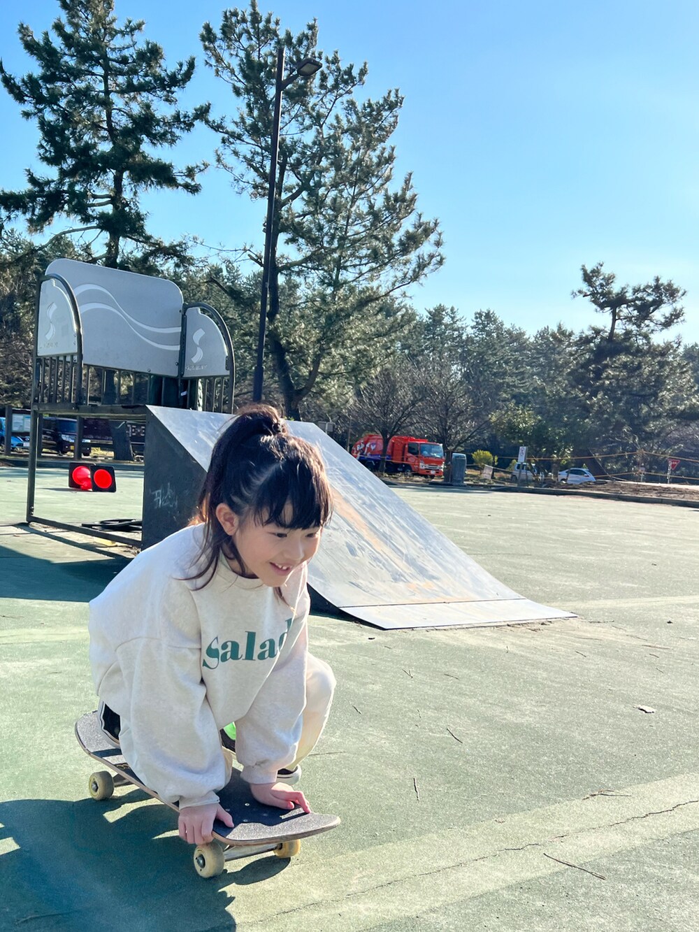 ベージュ系のスウェット、ホワイト系のカーゴパンツ、ブラック系のスニーカーを着用したキッズの冬コーディネートの4枚目の写真