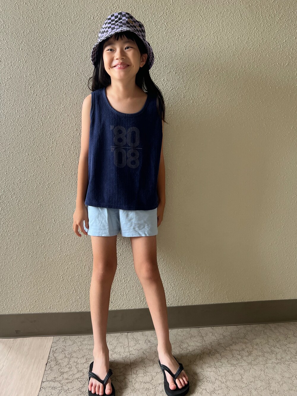 ブルー系のパンツ、ブルー系のタンクトップ、パープル系の帽子を着用したキッズの夏コーディネートの3枚目の写真