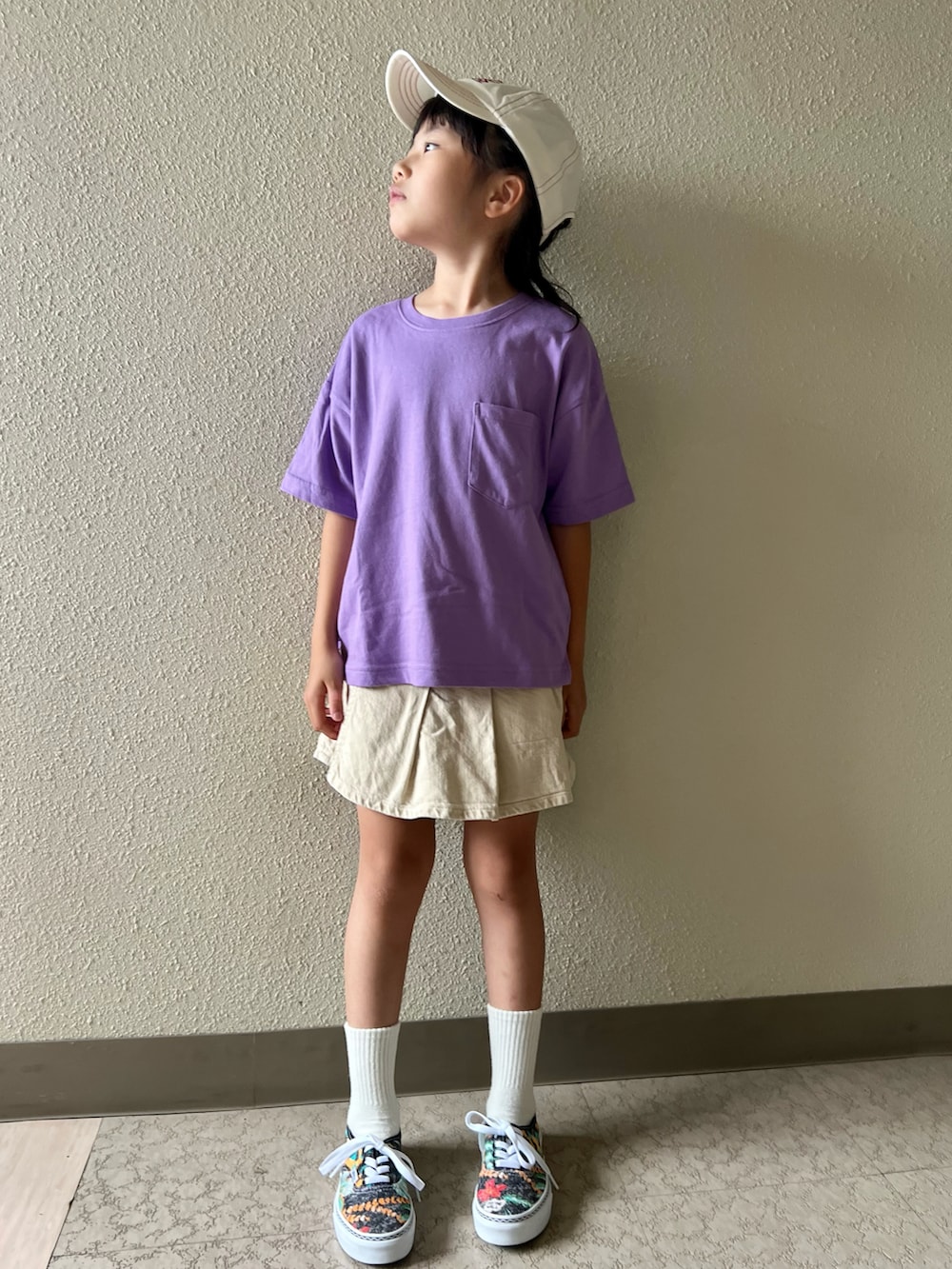 パープル系のTシャツ/カットソー、ベージュ系のスカート、その他のスニーカーを着用したキッズの春コーディネートの3枚目の写真