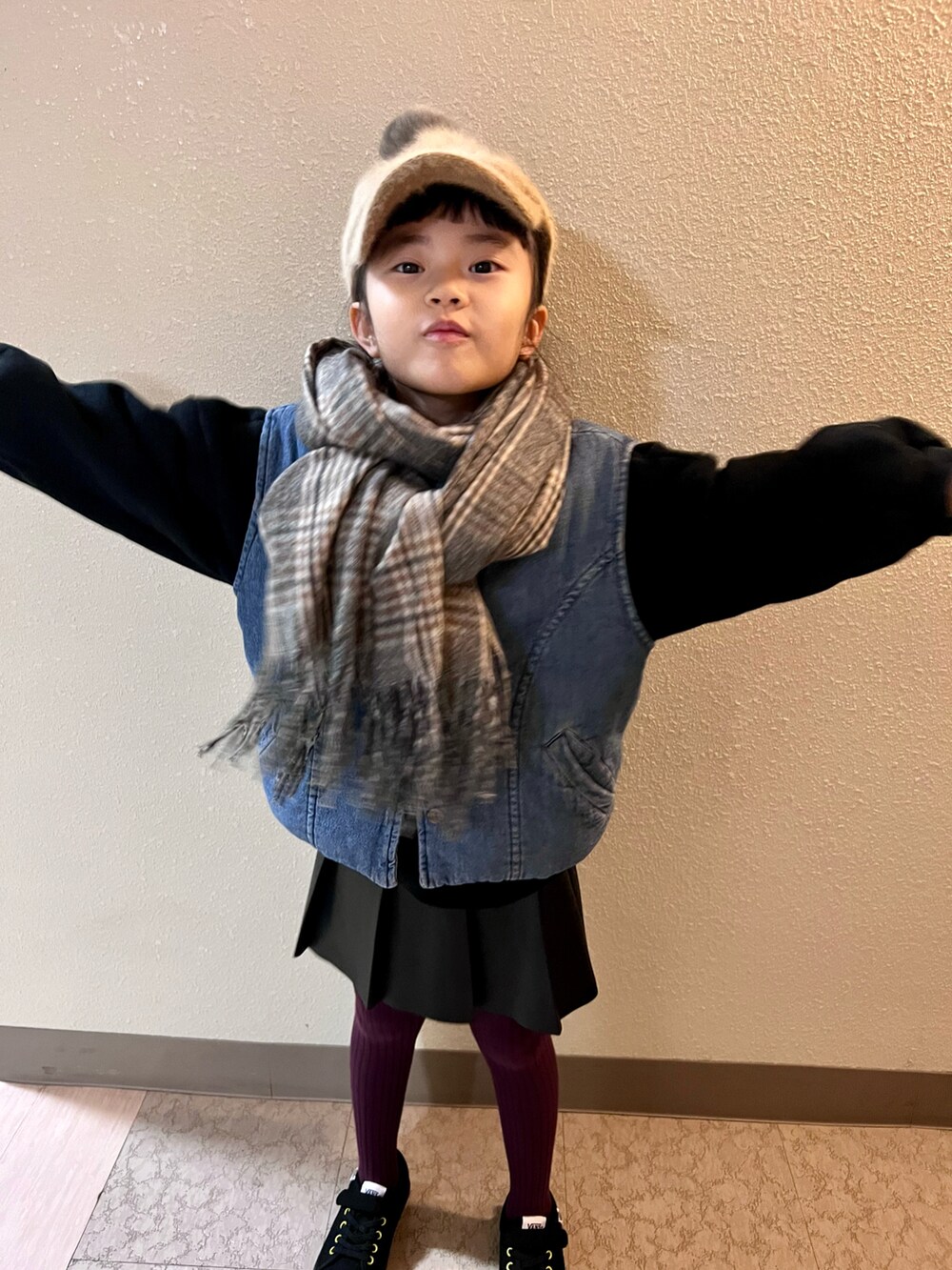 ブラック系のスニーカー、ブルー系のデニムジャケット、ブラック系のスカートを着用したキッズの冬コーディネートの3枚目の写真