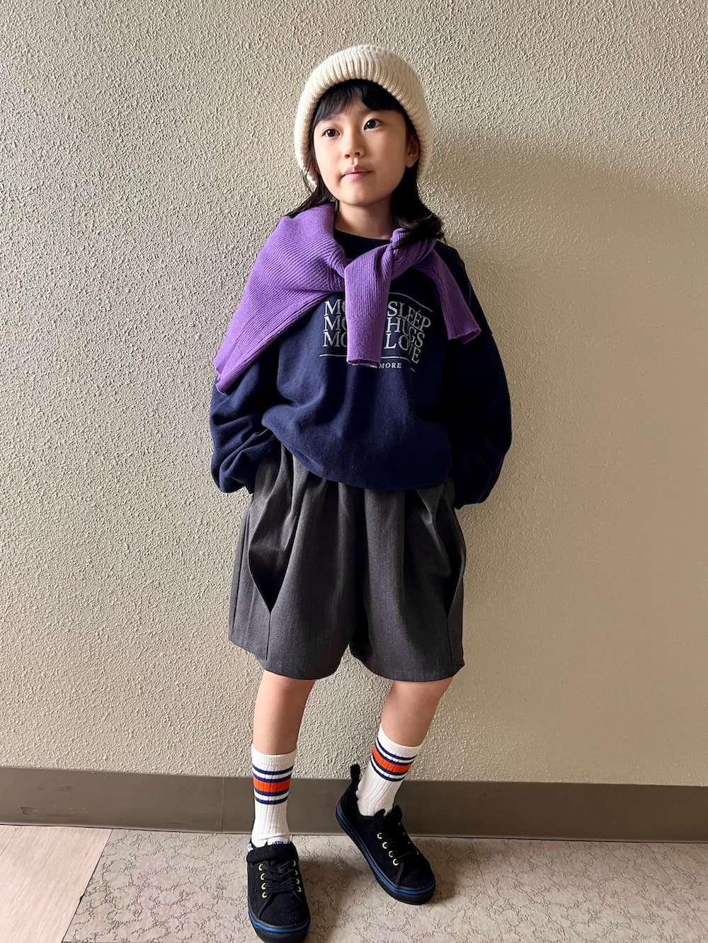 パープル系のカーディガン/ボレロ、ブルー系のスウェット、グレー系のその他パンツを着用したキッズの冬コーディネートの2枚目の写真