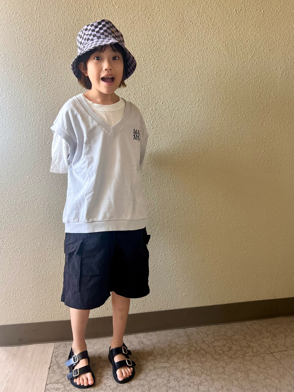 ブラック系のカーゴパンツ、グレー系のタンクトップ、パープル系の帽子を着用したキッズの春コーディネートの3枚目の写真