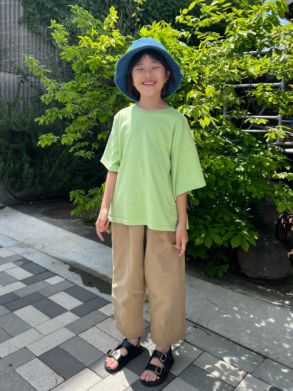 ホワイト系のカーゴパンツ、グリーン系のTシャツ/カットソー、ブルー系のハットを着用したキッズの春コーディネートの2枚目の写真