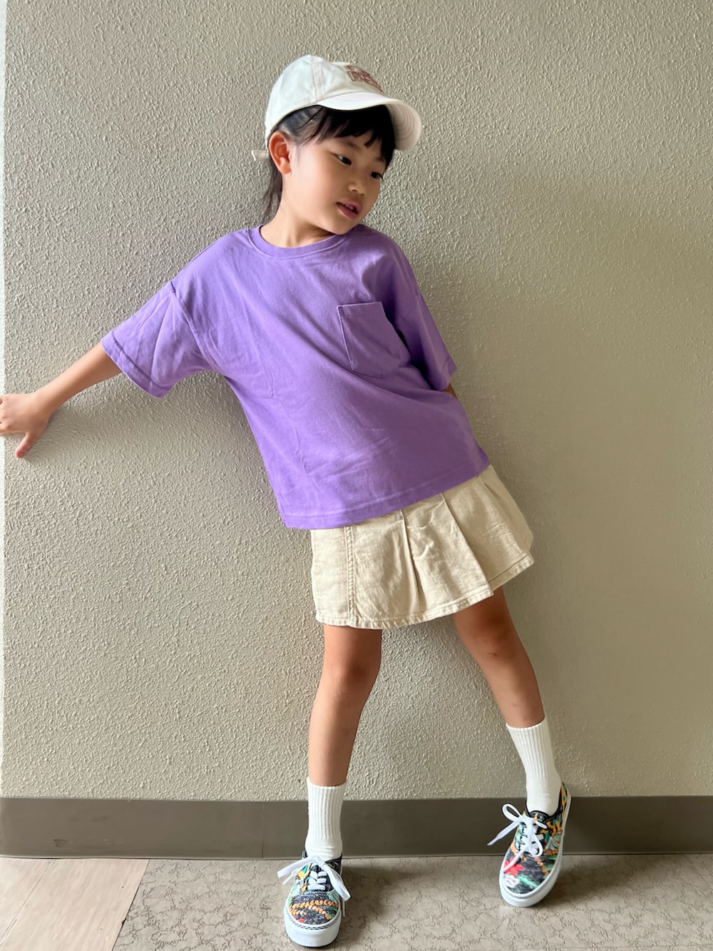 パープル系のTシャツ/カットソー、ベージュ系のスカート、その他のスニーカーを着用したキッズの春コーディネートの2枚目の写真