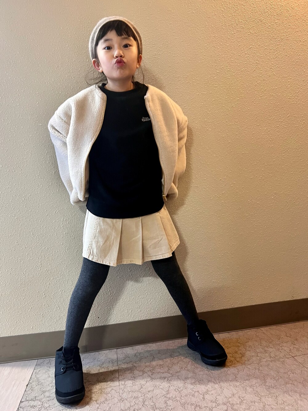 ホワイト系のブルゾン、ブラック系のスウェット、ベージュ系のスカートを着用したキッズの冬コーディネートの3枚目の写真
