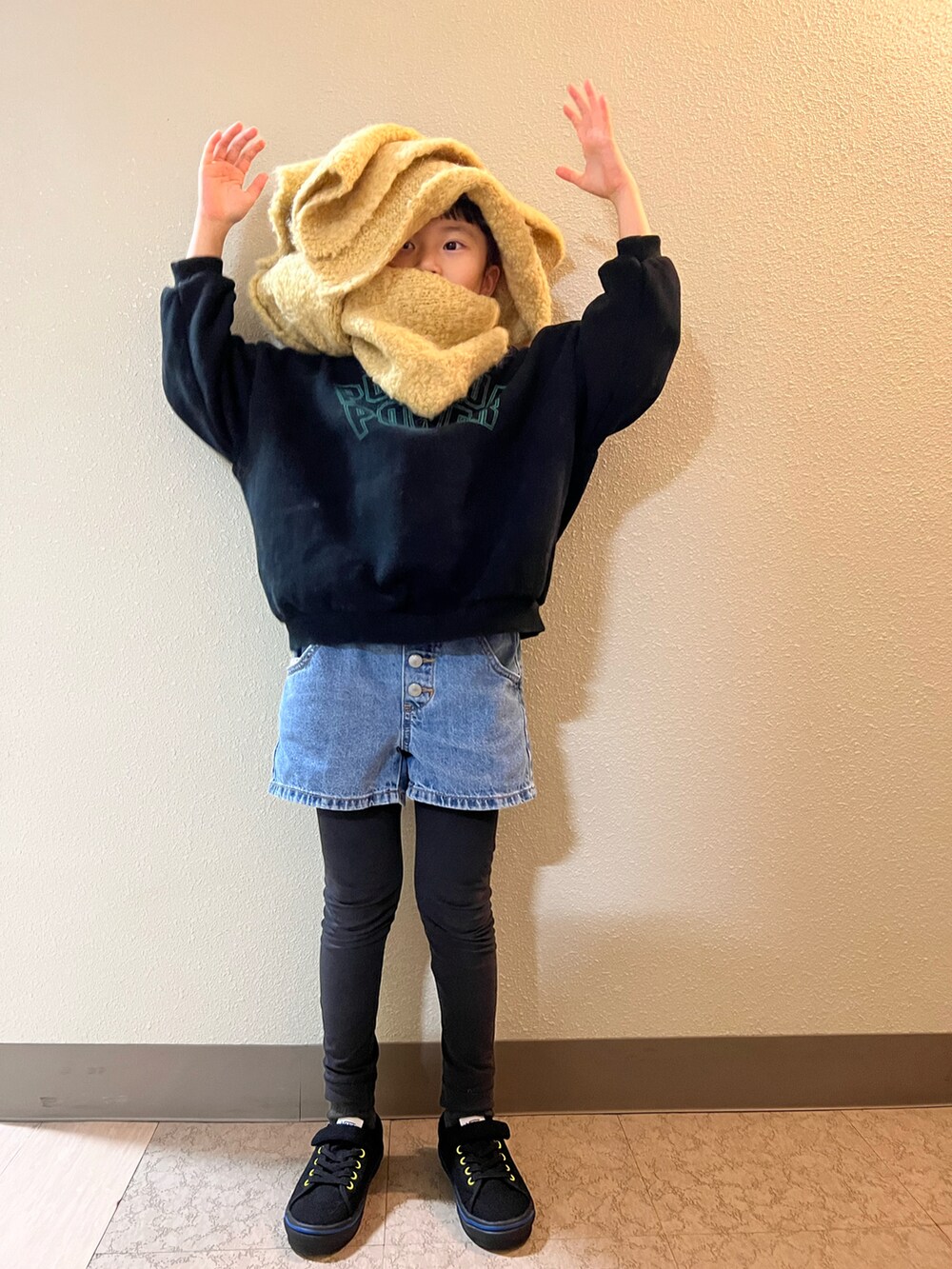 ブルー系のデニムパンツ、ブラック系のスウェット、ブラック系のスニーカーを着用したキッズの冬コーディネートの2枚目の写真
