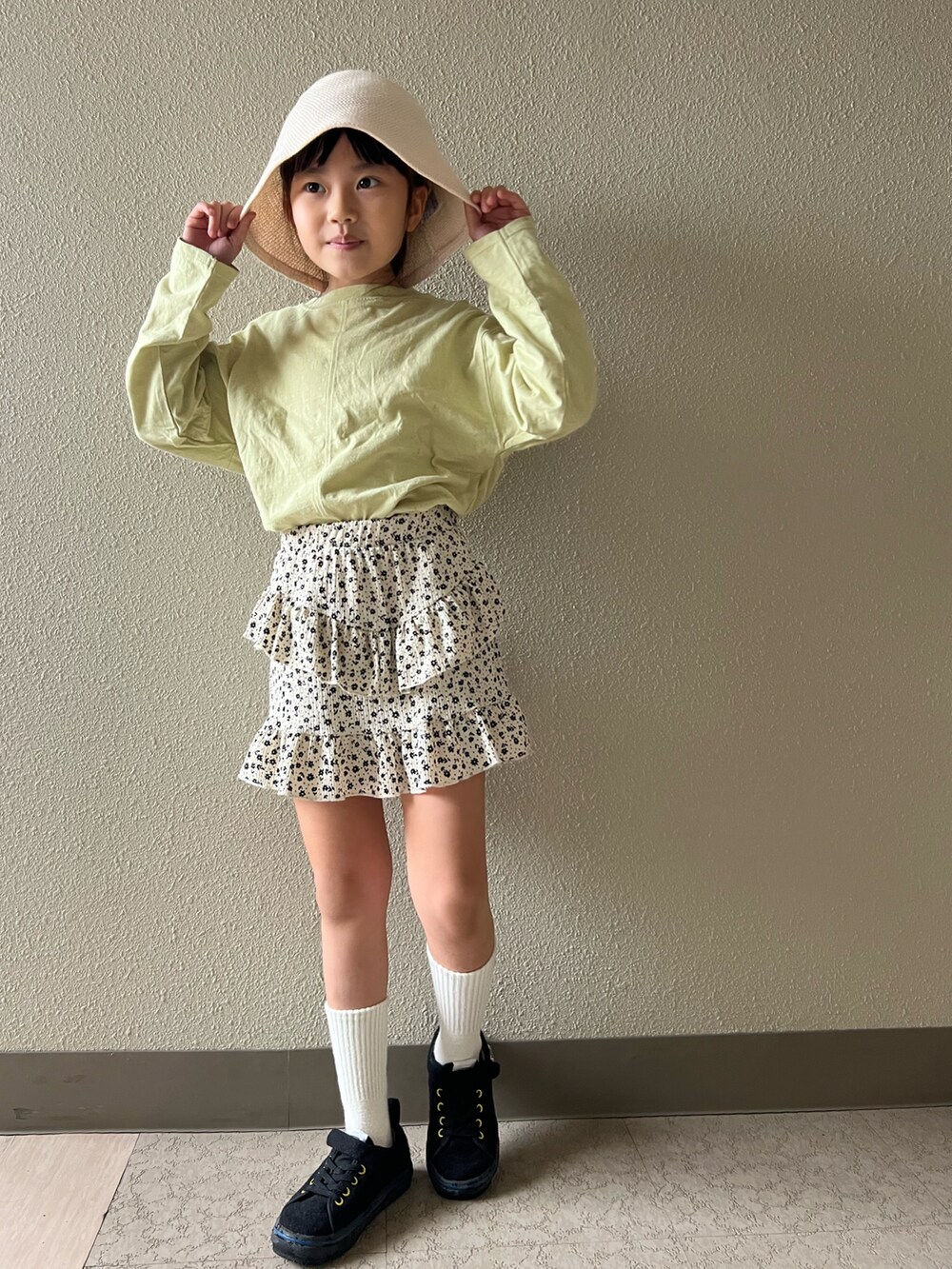 グリーン系のTシャツ/カットソー、ホワイト系のスカート、ブラック系のスニーカーを着用したキッズの春コーディネートの4枚目の写真