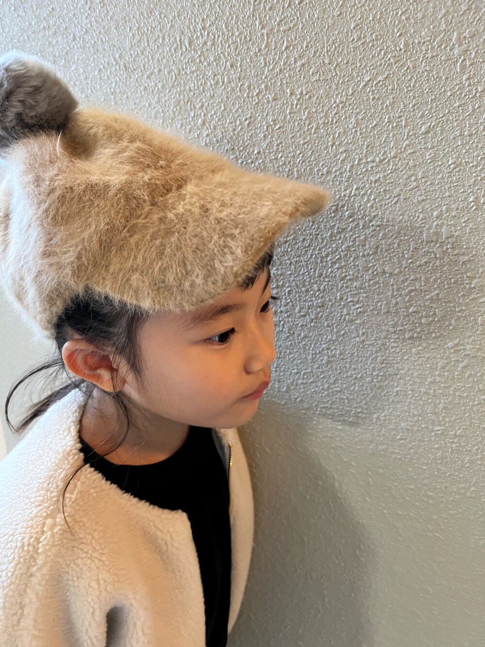 ブラック系のスウェット、ブルー系のデニムパンツ、ブラック系のブーツを着用したキッズの冬コーディネートの3枚目の写真