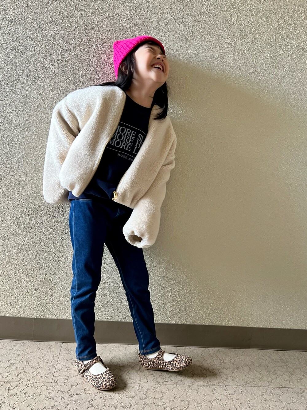 ブルー系のスウェット、ブルー系のデニムパンツ、ブラウン系のバレエシューズを着用したキッズの冬コーディネートの3枚目の写真