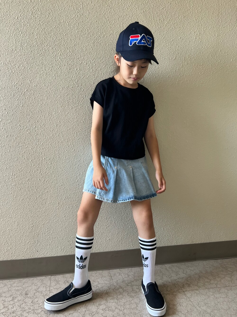 ブラック系のTシャツ/カットソー、ブルー系のデニムスカート、ブラック系のスニーカーを着用したキッズの夏コーディネートの4枚目の写真