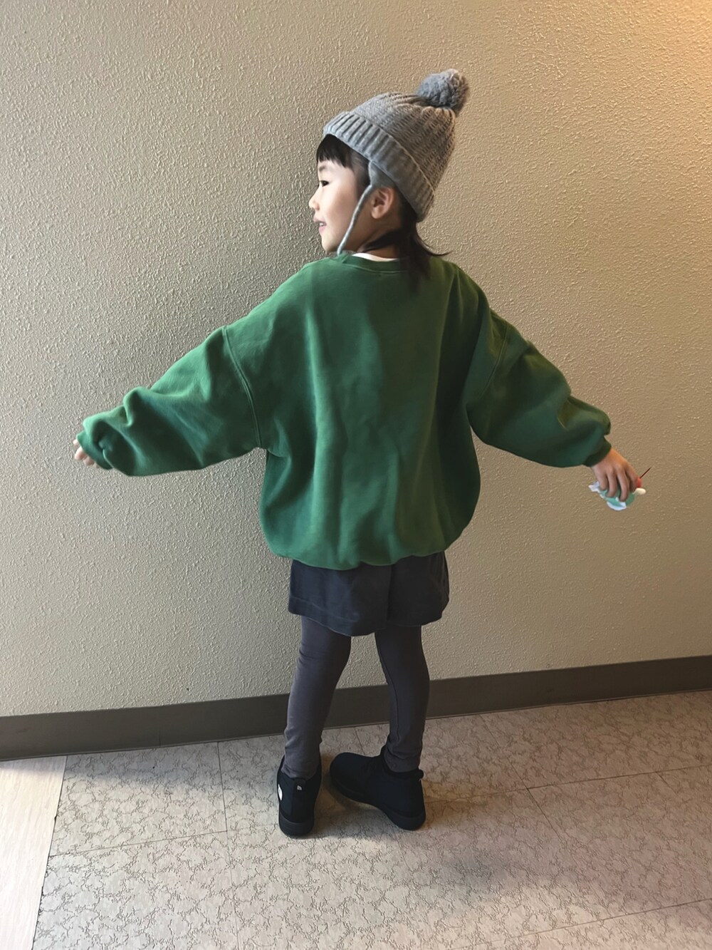 グリーン系のスウェット、グレー系のパンツ、ブラック系のブーツを着用したキッズの冬コーディネートの4枚目の写真