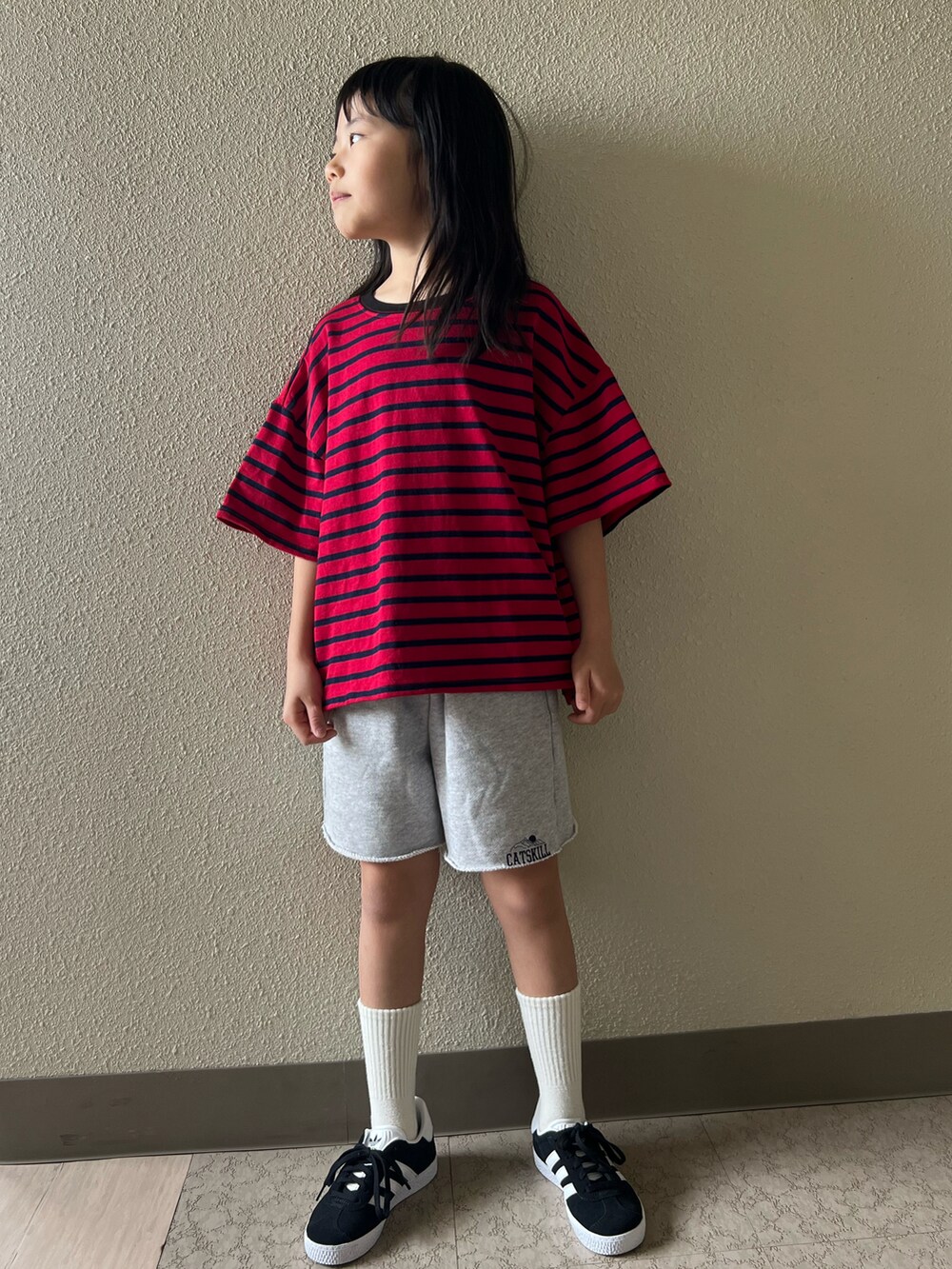 レッド系のTシャツ/カットソー、グレー系のスウェットパンツ、ブラック系のスニーカーを着用したキッズの春コーディネートの2枚目の写真