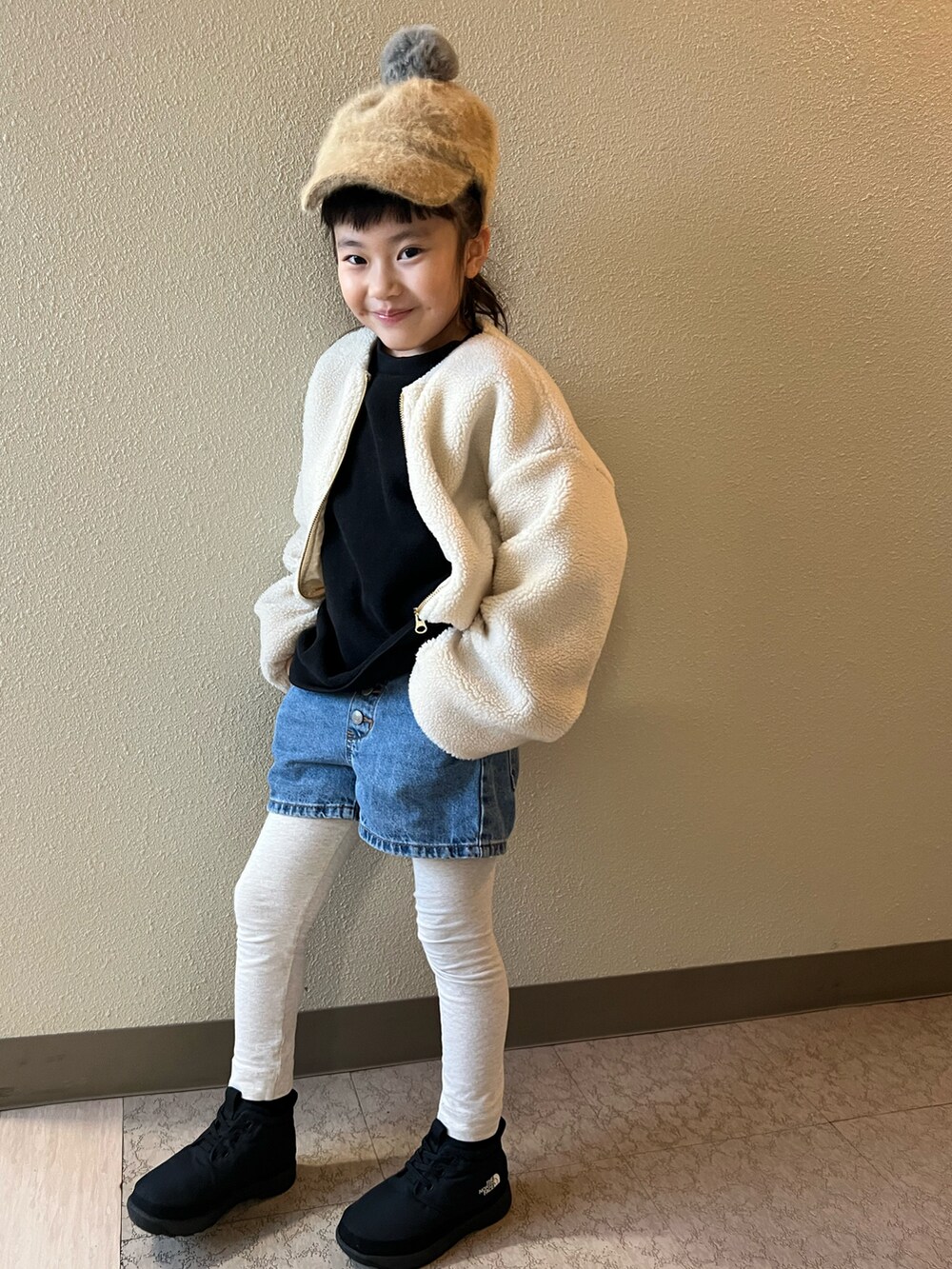 ブラック系のスウェット、ブルー系のデニムパンツ、ブラック系のブーツを着用したキッズの冬コーディネートの2枚目の写真