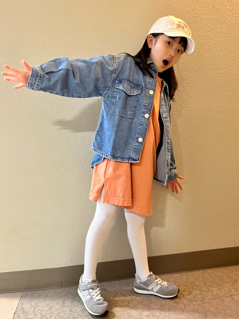 オレンジ系のワンピース、ブルー系のシャツ/ブラウス、グレー系のスニーカーを着用したキッズの冬コーディネートの2枚目の写真