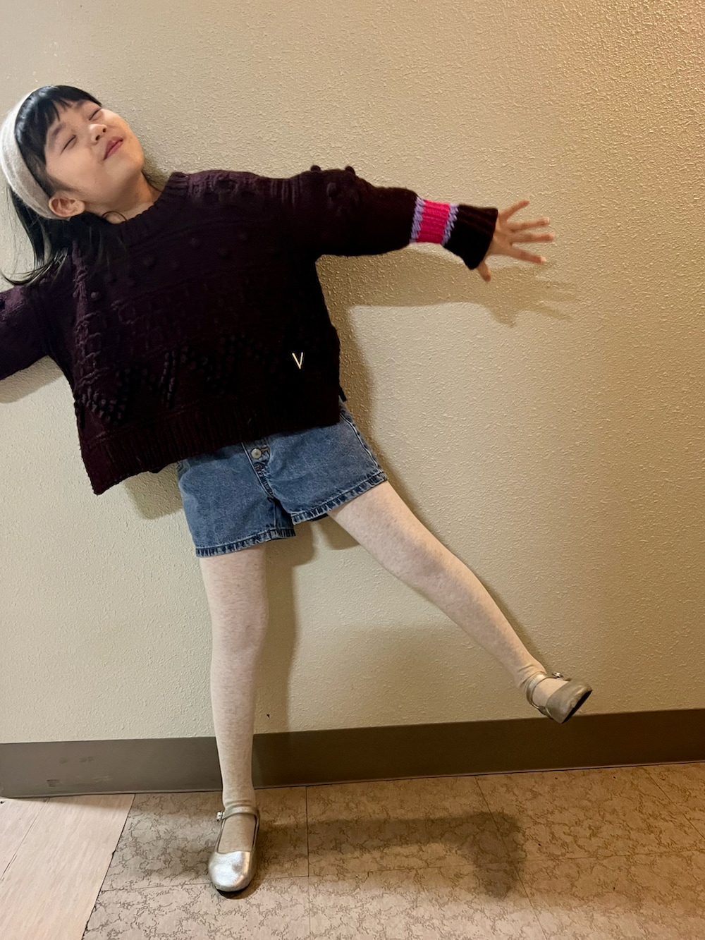 ブラウン系のニット/セーター、ブルー系のデニムパンツ、シルバー系のバレエシューズを着用したキッズの冬コーディネートの4枚目の写真