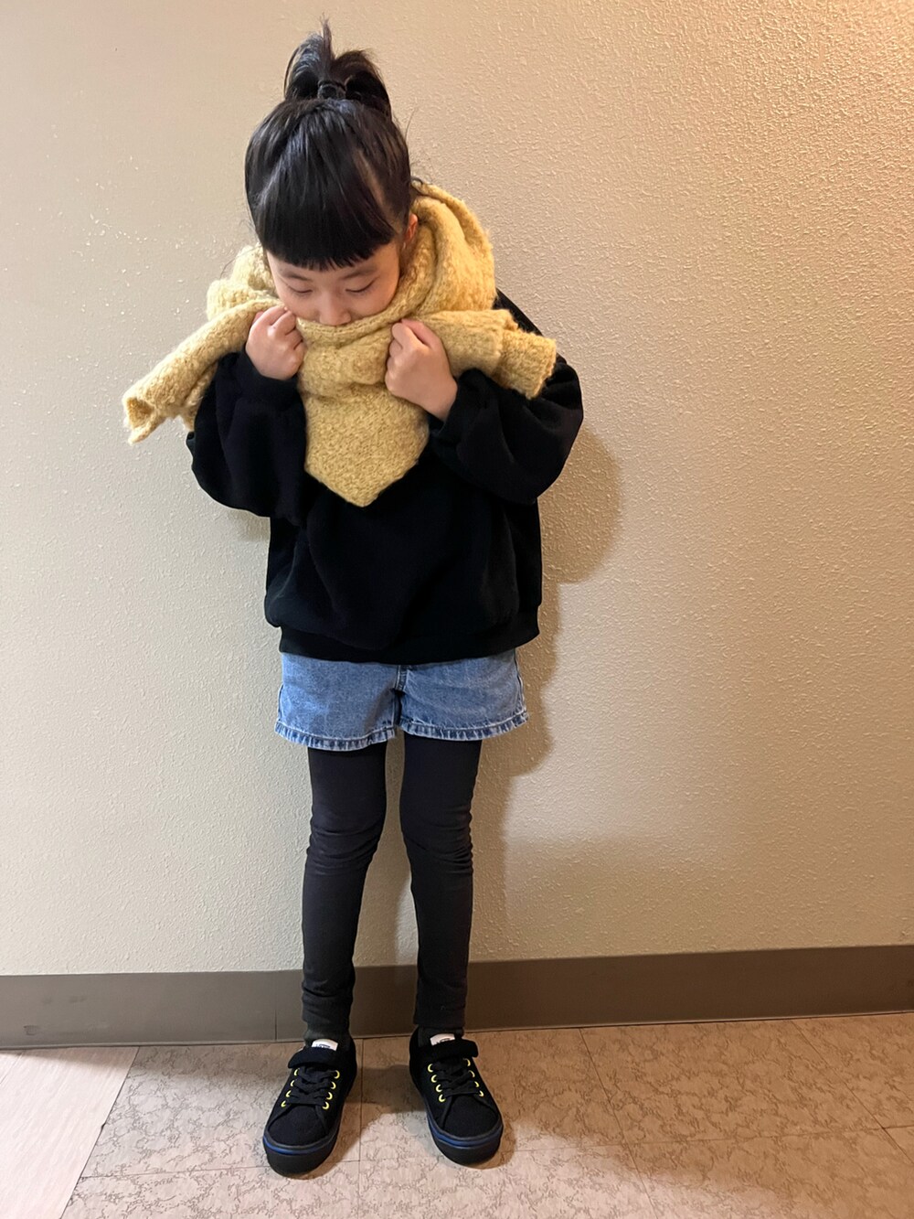 ブルー系のデニムパンツ、ブラック系のスウェット、ブラック系のスニーカーを着用したキッズの冬コーディネートの3枚目の写真
