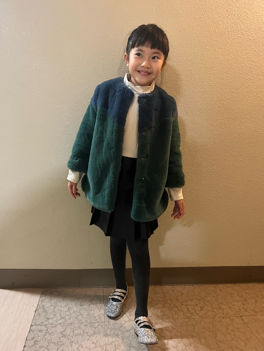 「クリスマスに着たい服、キッズファッション、女の子コーデ、モード、ファーコート、ミニスカート、おんなのこ、小学生、おだんごヘアー、もこもこ、冬コーデ、レザー、スカート、バレエシューズ」｜「venitのアイテム（ムートンコート、グリーン系）」を使った、pecocoさん（キッズ・120cm）の冬コーディネートの2枚目の写真