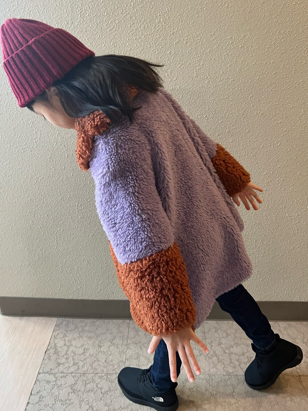 パープル系のジャケット/アウター、ブルー系のデニムパンツ、ブラック系のブーツを着用したキッズの冬コーディネートの4枚目の写真