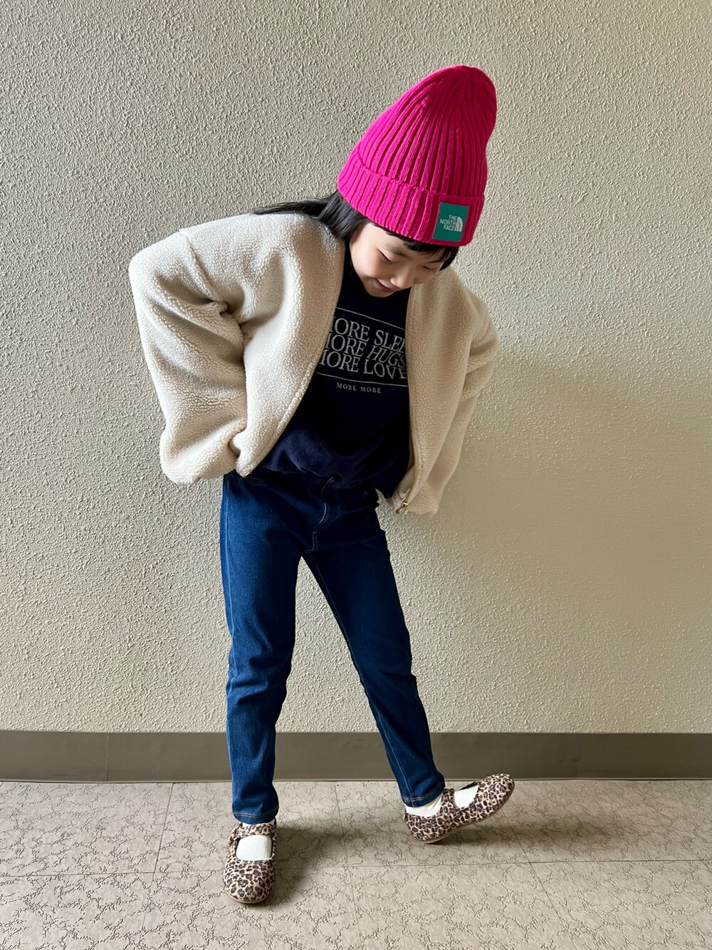 ブルー系のスウェット、ブルー系のデニムパンツ、ブラウン系のバレエシューズを着用したキッズの冬コーディネートの4枚目の写真