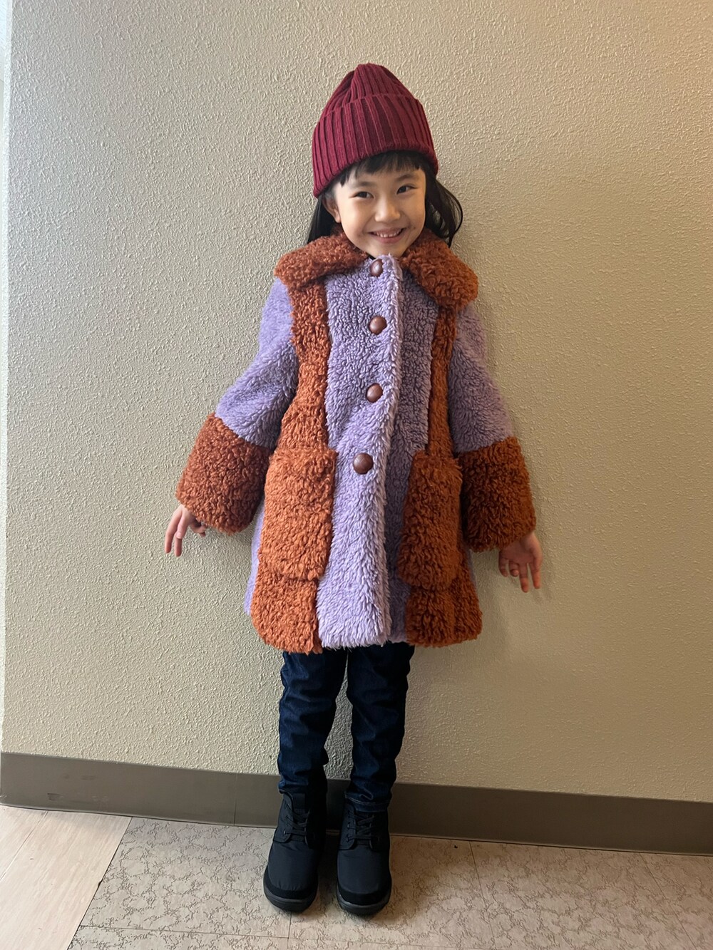 パープル系のジャケット/アウター、ブルー系のデニムパンツ、ブラック系のブーツを着用したキッズの冬コーディネートの2枚目の写真