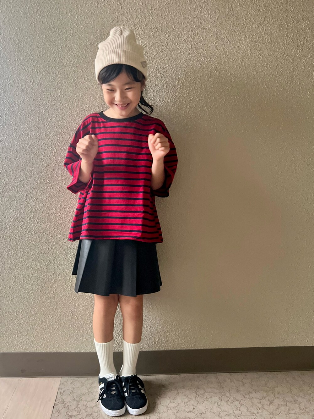 レッド系のTシャツ/カットソー、ブラック系のスカート、ブラック系のスニーカーを着用したキッズの春コーディネートの4枚目の写真