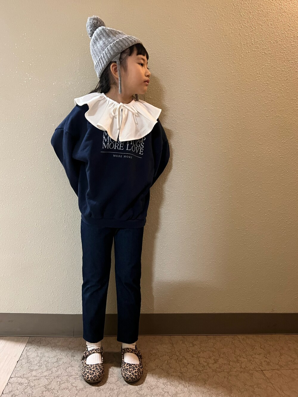 ブルー系のスウェット、ブルー系のデニムパンツ、ブラウン系のバレエシューズを着用したキッズの冬コーディネートの2枚目の写真