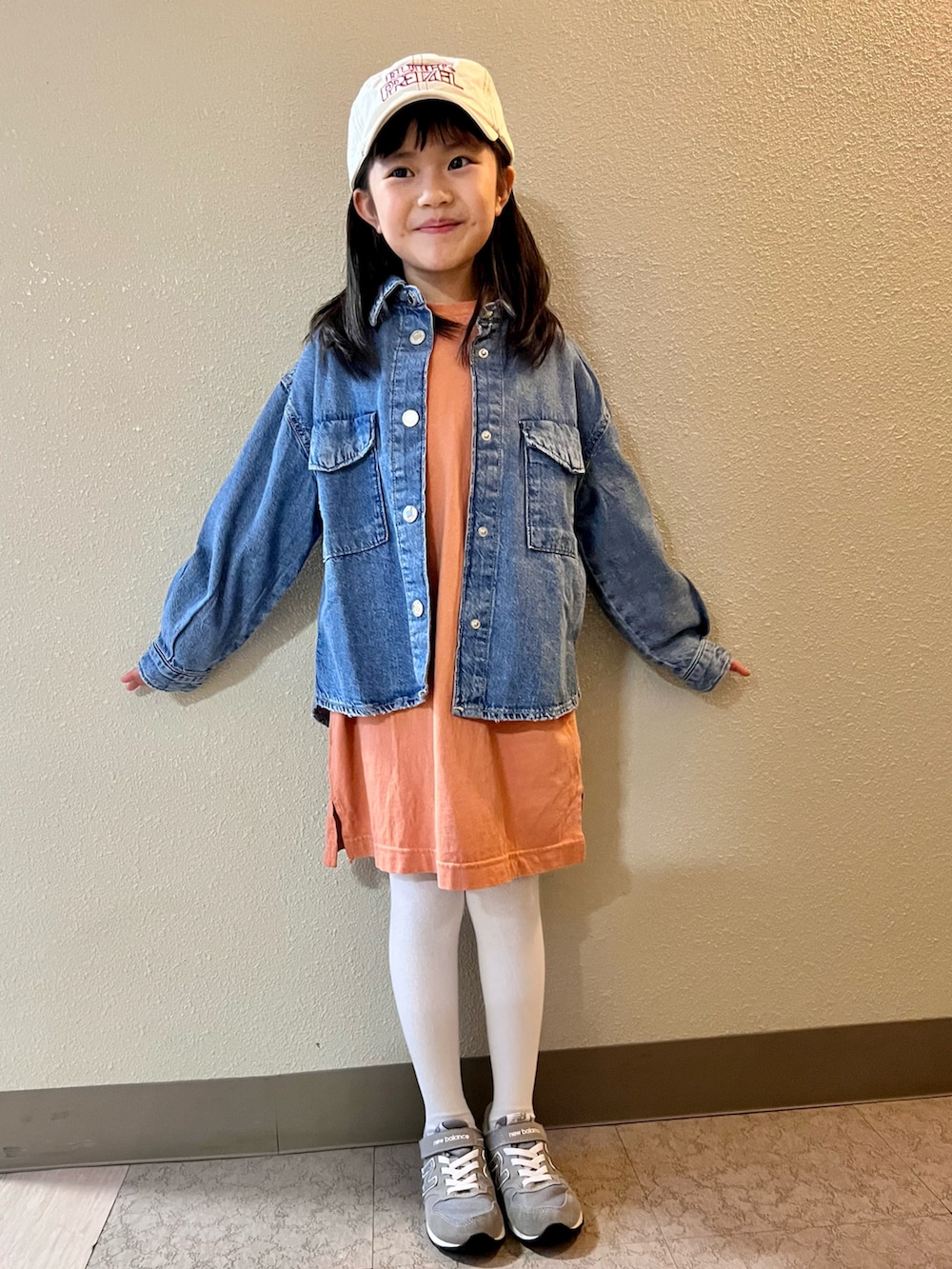 オレンジ系のワンピース、ブルー系のシャツ/ブラウス、グレー系のスニーカーを着用したキッズの冬コーディネートの3枚目の写真